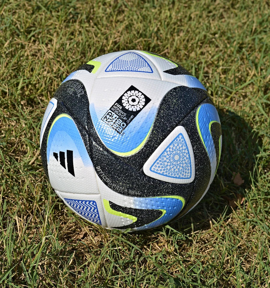 Pallone Adidas Oceaunz Pro – dettaglio pannelli azzurri con motivi aborigeni e verde fluo