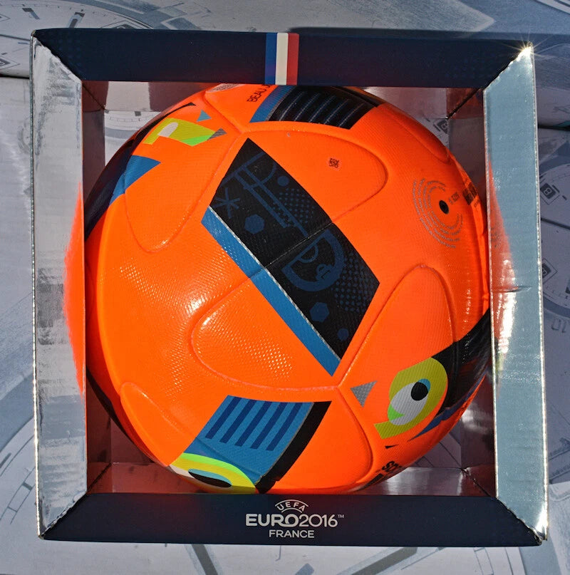 Pallone Adidas Beau Jeu Winter – dettaglio pannelli arancio e nero su erba