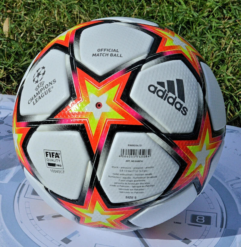 Pallone Adidas UCL 2021-2022 – dettaglio pannelli bianchi e stella rossa arancio giallo