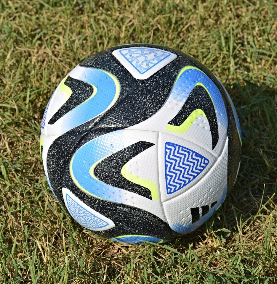 Pallone Adidas Oceaunz Pro – dettaglio pannelli bianchi con motivi Maori blu e verde fluo