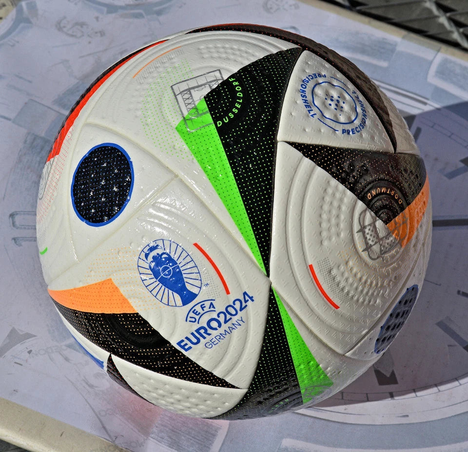 Pallone Adidas Fussballliebe Pro – vista completa con pannelli verde fluo e rosso su erba