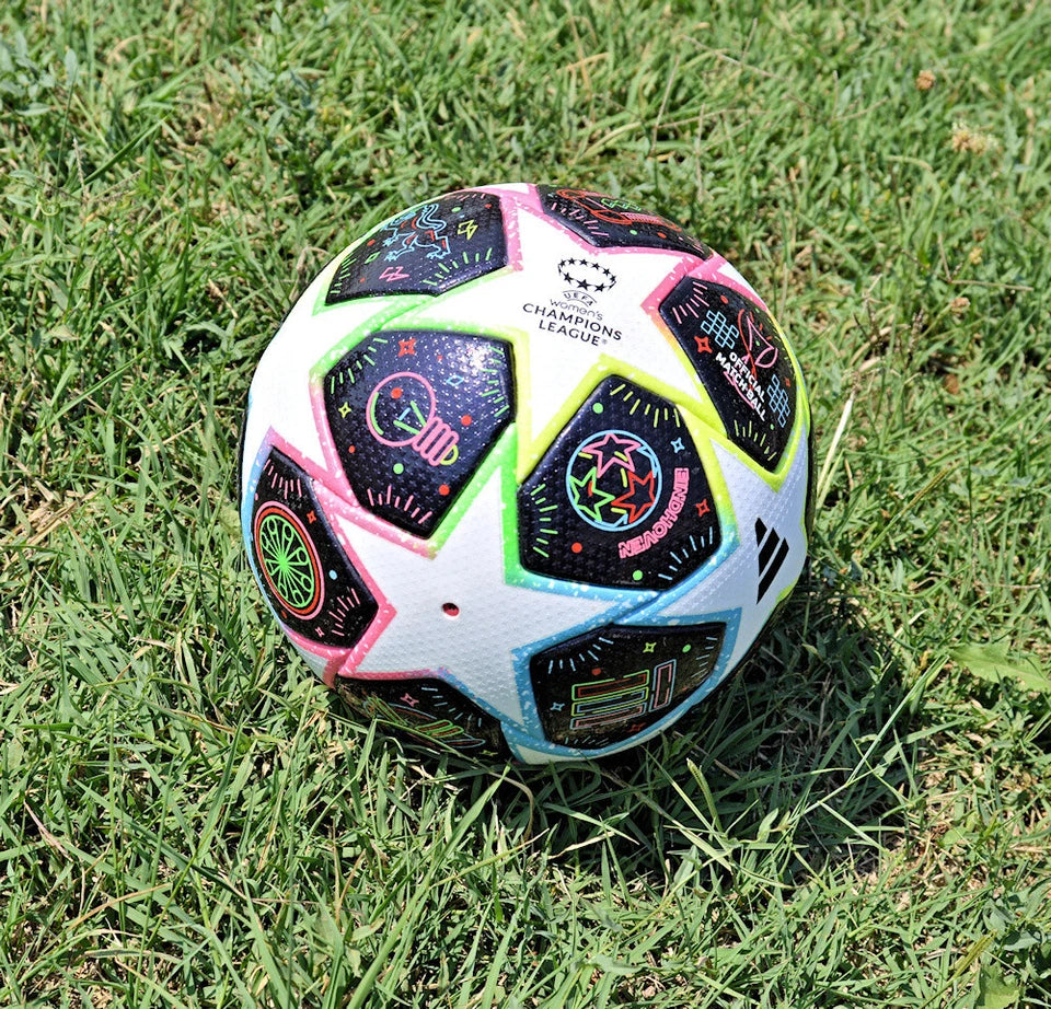 Pallone Adidas Eindhoven Final 23 – vista completa su erba con stella Champions League e pannelli neon